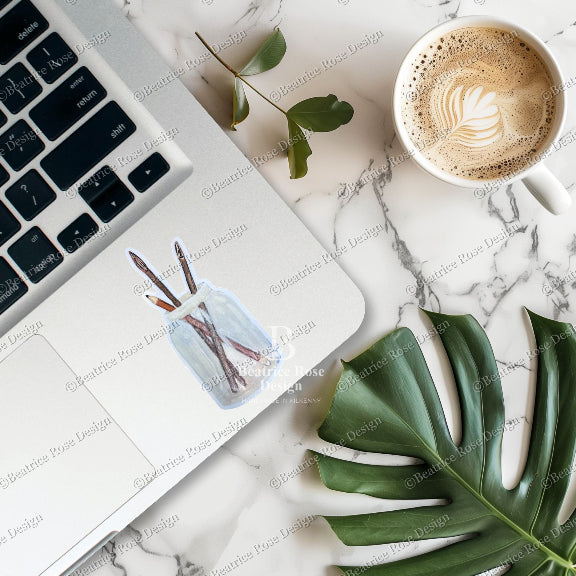 Laptop on a marble surface with a cup of coffee and a plant leaf.