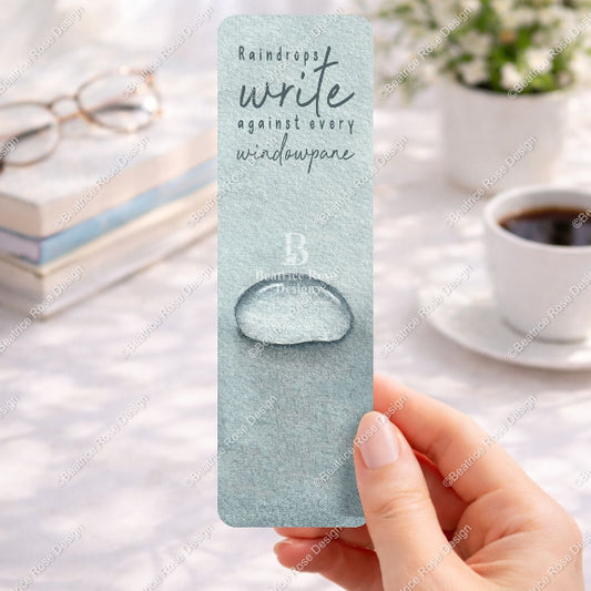 Hand holding a bookmark with water droplet design and text on a desk with books and coffee.