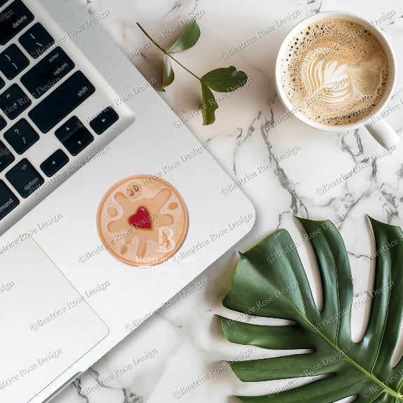 Laptop with a cup of coffee and a cookie on a marble surface
