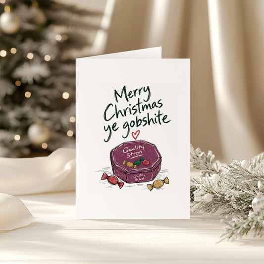 Merry Christmas Ye Gobshite funny Irish Christmas card featuring a Quality Street chocolate tin and colourful Christmas sweets