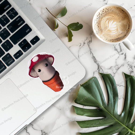 Laptop with a small figurine wearing a red hat and orange shirt on a marble surface with a cup of coffee and leaves.