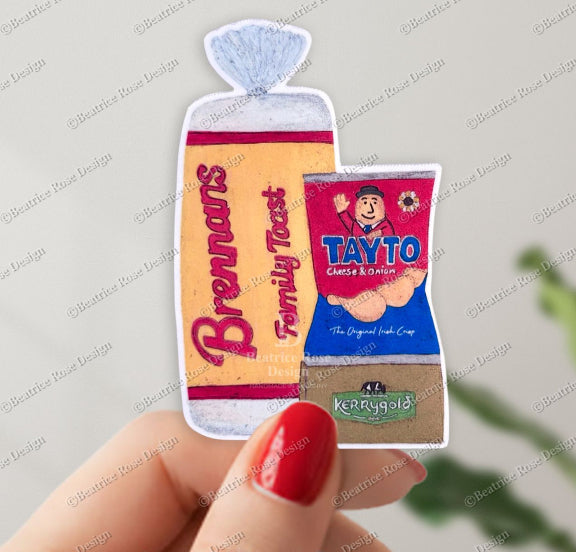 Three miniature food packages held by a hand with red nail polish on a light gray background.