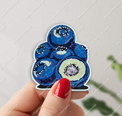 Sticker of blueberries held by a hand with red nail polish on a light gray background